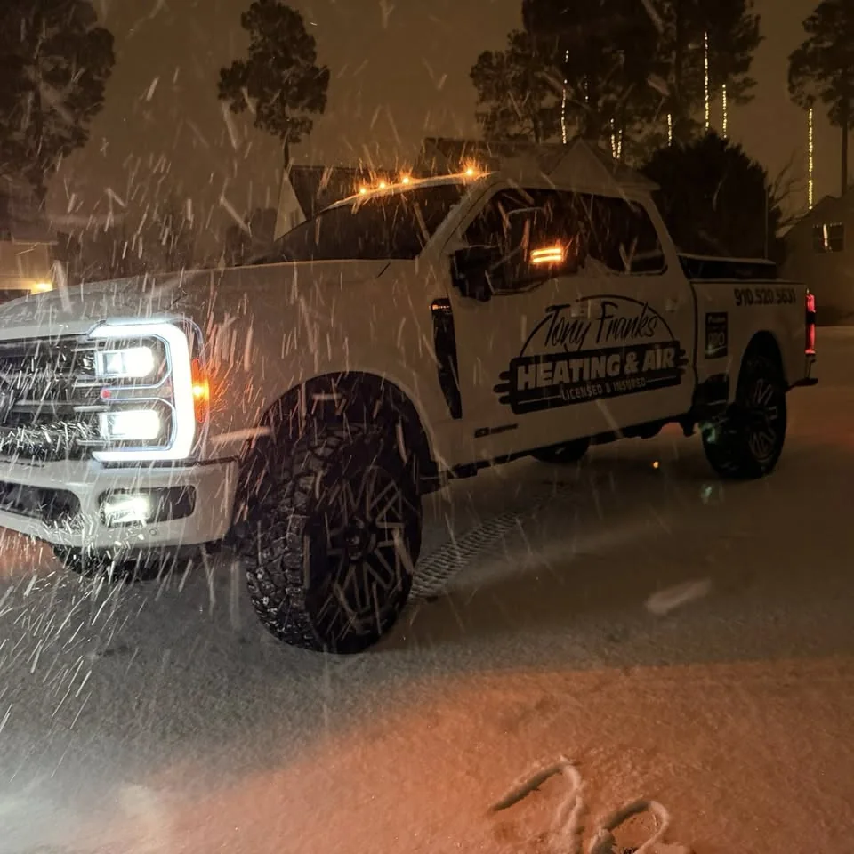 Tony Franks Heating and Air branded truck out working in a snowstorm at night